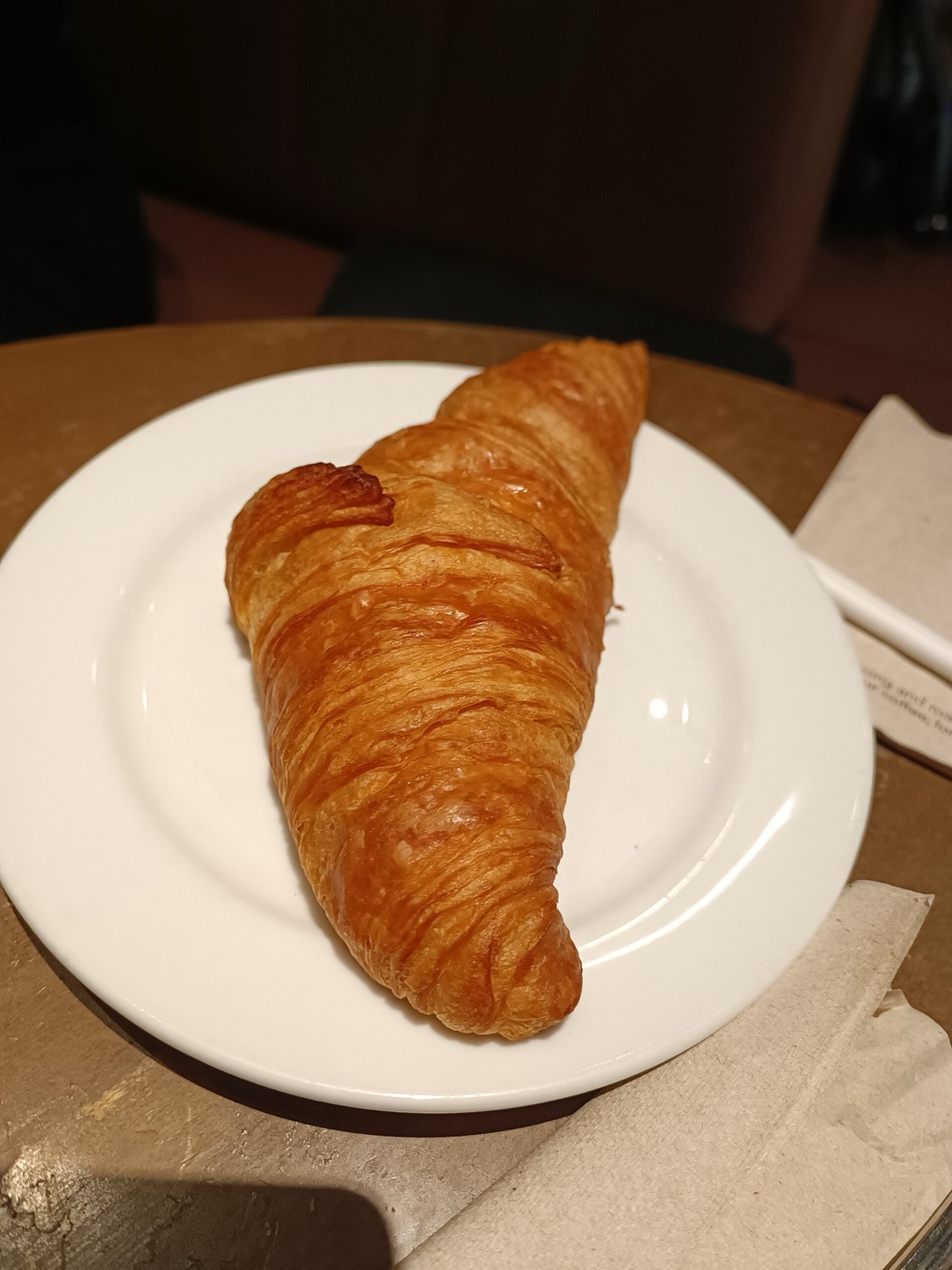 A butter croissant on a white plate